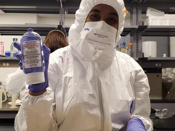 Shylaja Ramamurthy holding a bottle of VVL-made hand sanitizer, mid-Covid Pandemic. 